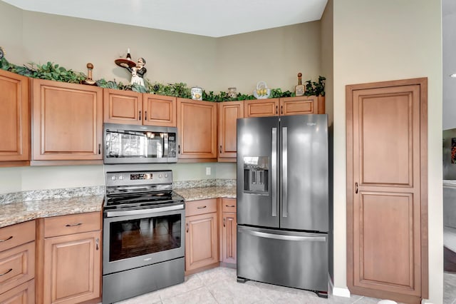 227 Legendary Cir, Palm Beach Gardens, FL 33418 - kitchen featuring appliances with stainless steel finishes, light stone countertops, and light tile patterned flooring