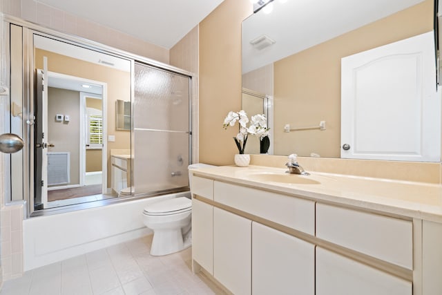 full bathroom featuring toilet, vanity, tile patterned flooring, and enclosed tub / shower combo