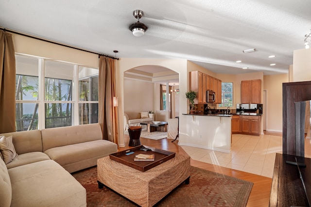 living room featuring sink, a textured ceiling, and light tile patterned floors