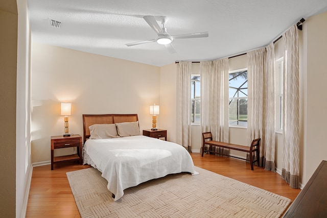 bedroom featuring ceiling fan, a textured ceiling, and light hardwood / wood-style floors