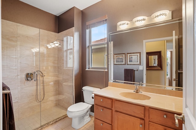 bathroom with tile patterned flooring, vanity, toilet, and a tile shower