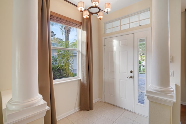 tiled entrance foyer with decorative columns and an inviting chandelier