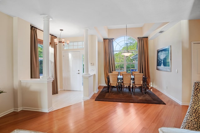 dining area featuring plenty of natural light, light wood-type flooring, and a notable chandelier