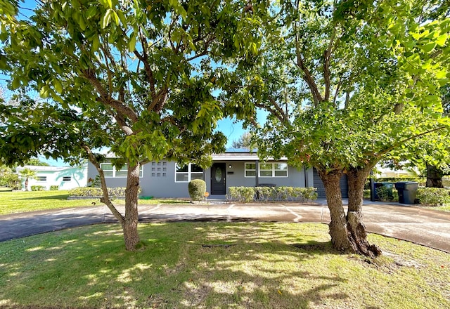 view of front facade with a front yard and solar panels