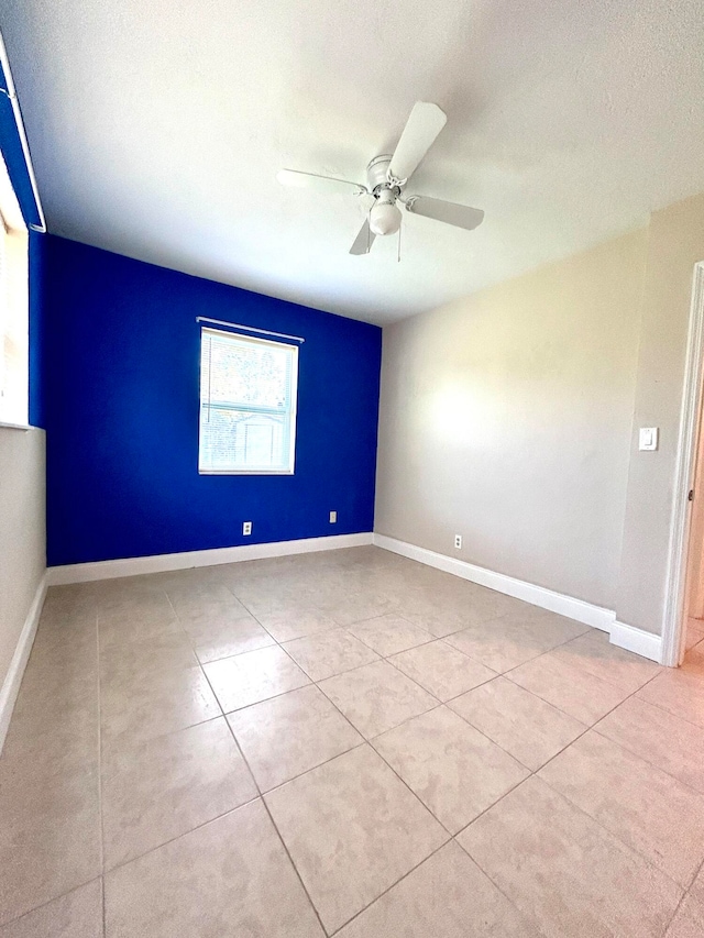 tiled spare room with ceiling fan and a textured ceiling