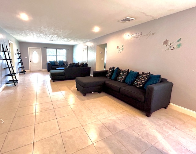 living room with a textured ceiling and light tile patterned floors