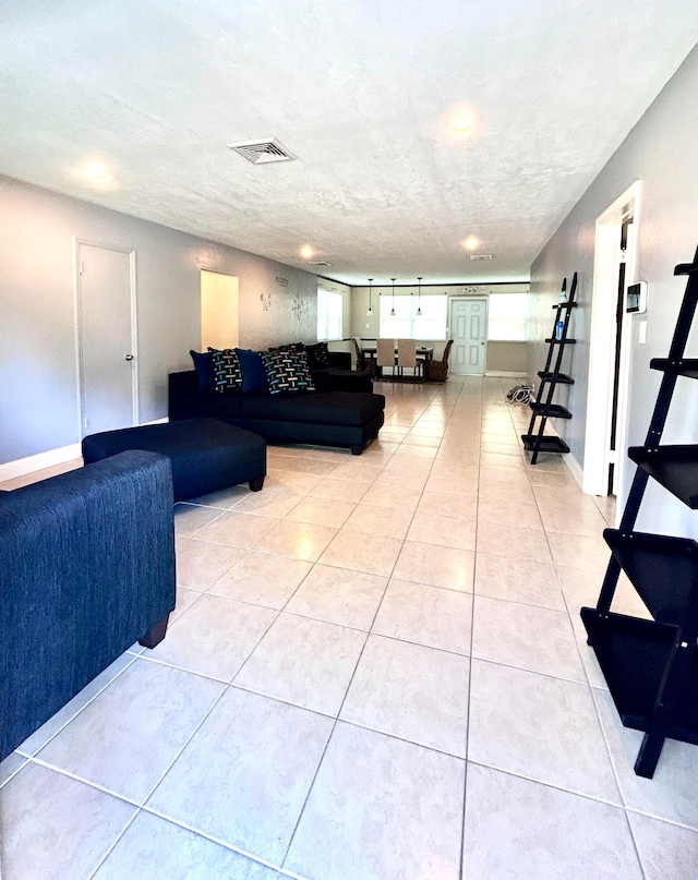 living room with a textured ceiling and light tile patterned floors