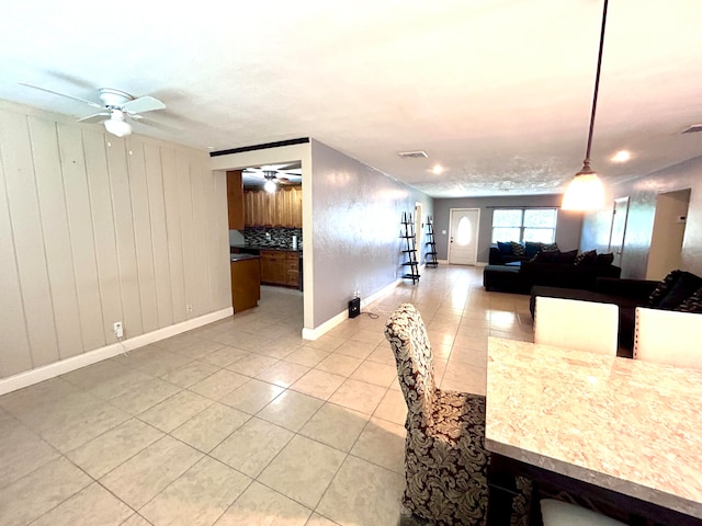 tiled dining space with ceiling fan