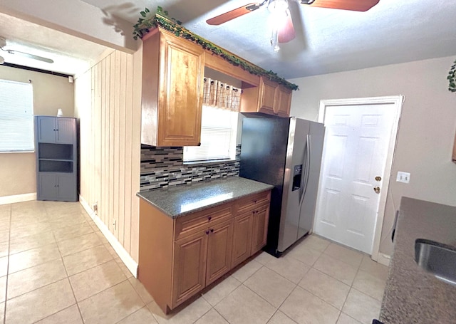 kitchen featuring light tile patterned floors, ceiling fan, backsplash, and stainless steel fridge