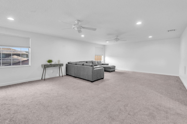 carpeted living room featuring ceiling fan, a healthy amount of sunlight, and a textured ceiling