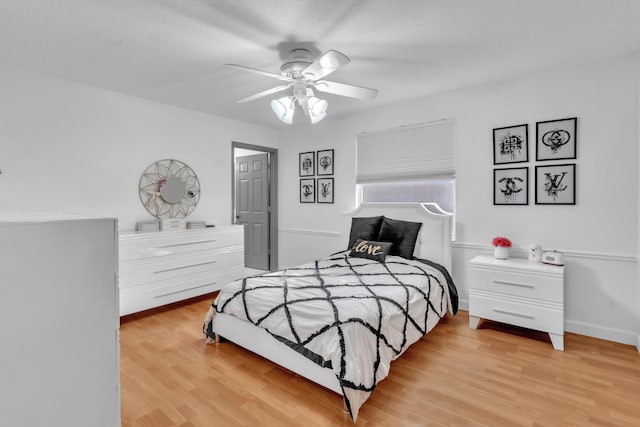 bedroom featuring ceiling fan, a textured ceiling, and light wood-type flooring