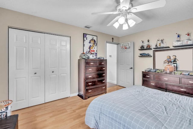 bedroom with ceiling fan, wood-type flooring, and a closet