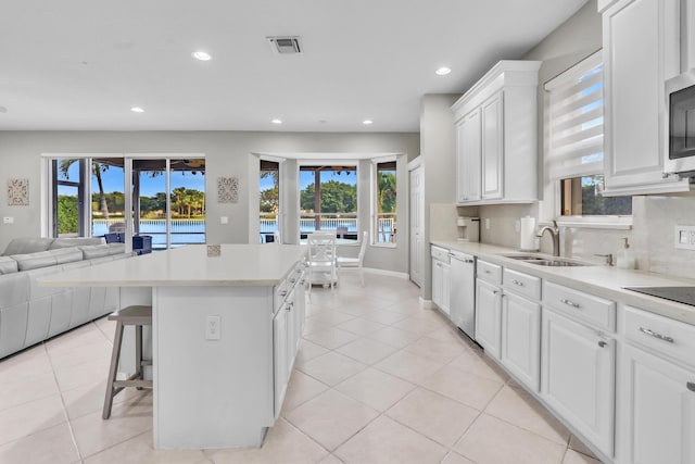 kitchen with white cabinetry, tasteful backsplash, a center island, and dishwasher