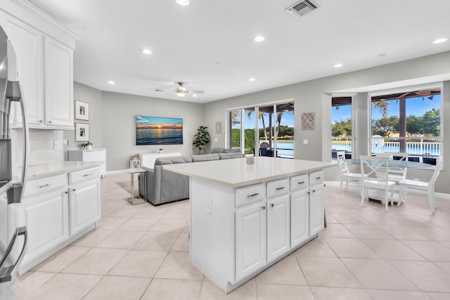 kitchen featuring light tile patterned floors, a kitchen island, and white cabinets