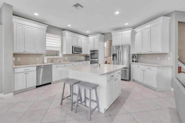 kitchen featuring white cabinetry, appliances with stainless steel finishes, and a center island