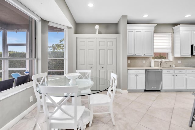 kitchen with stainless steel appliances, sink, decorative backsplash, and white cabinets