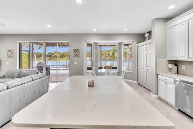 kitchen with white cabinetry, dishwasher, a wealth of natural light, and light stone counters