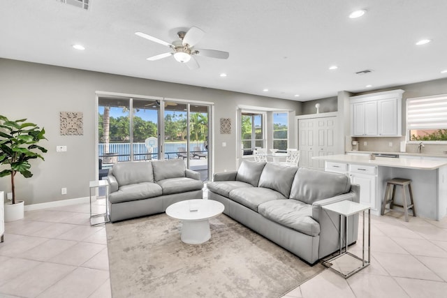 living room with a healthy amount of sunlight, light tile patterned floors, and ceiling fan