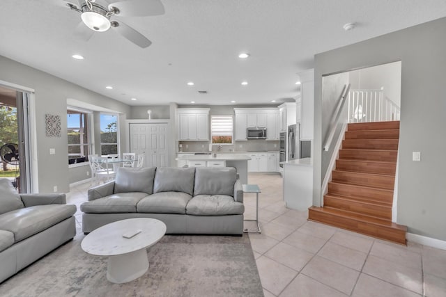 living room with light tile patterned flooring, ceiling fan, and plenty of natural light