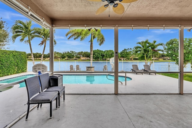 view of swimming pool with a patio, ceiling fan, and a water view