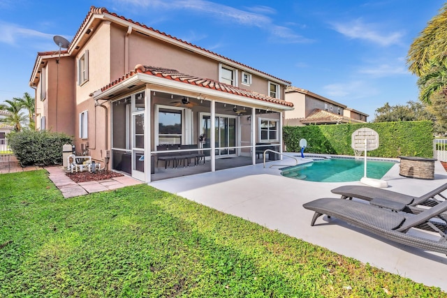 rear view of property featuring a fenced in pool, a patio, a sunroom, and ceiling fan