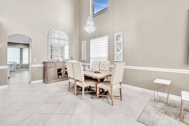 dining room featuring a towering ceiling and light tile patterned floors