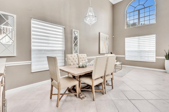 tiled dining area with a chandelier and a high ceiling