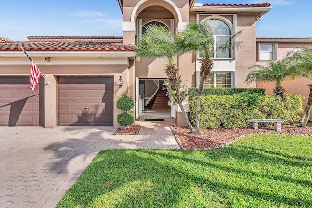 mediterranean / spanish-style house featuring a garage and a front lawn