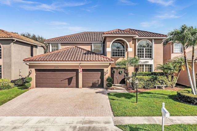 mediterranean / spanish house featuring a garage and a front lawn