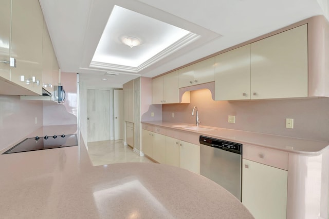 kitchen featuring a raised ceiling, sink, cream cabinets, and appliances with stainless steel finishes