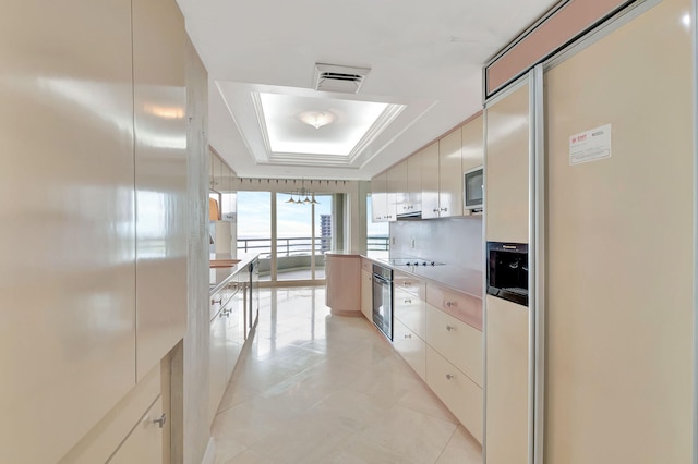 kitchen with a raised ceiling, light tile patterned floors, appliances with stainless steel finishes, and tasteful backsplash