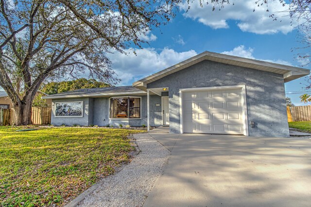 single story home featuring a front lawn and a garage