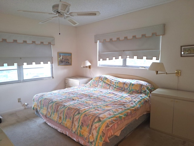 bedroom featuring multiple windows, a textured ceiling, carpet flooring, and ceiling fan