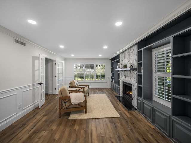 living room with a fireplace, dark hardwood / wood-style flooring, and crown molding