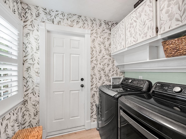 laundry area with washer and clothes dryer, cabinets, and light wood-type flooring