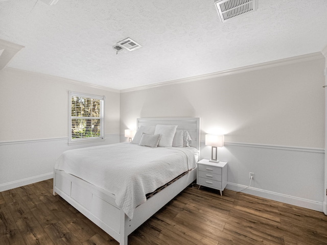 bedroom featuring crown molding, dark hardwood / wood-style flooring, and a textured ceiling