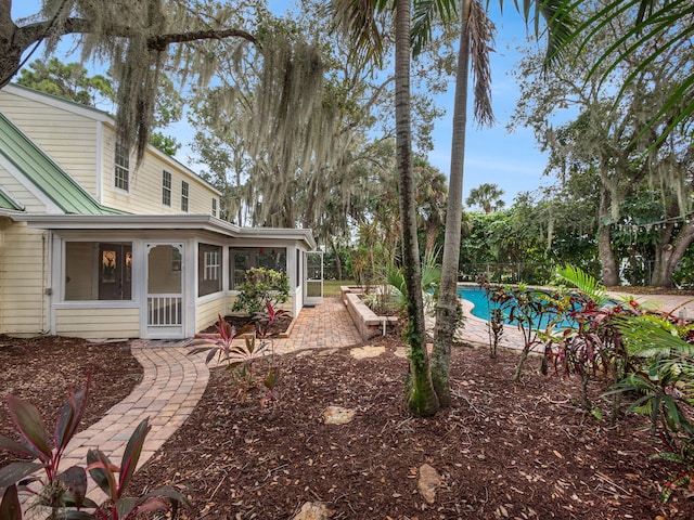 view of yard featuring a sunroom and a patio