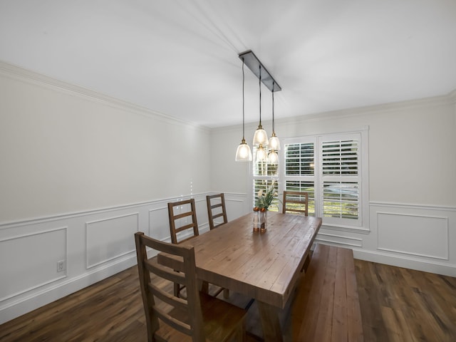 dining area with dark wood-type flooring, crown molding, and an inviting chandelier