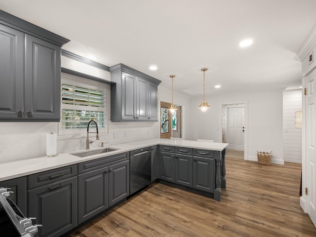 kitchen featuring sink, stainless steel dishwasher, dark hardwood / wood-style floors, kitchen peninsula, and decorative light fixtures