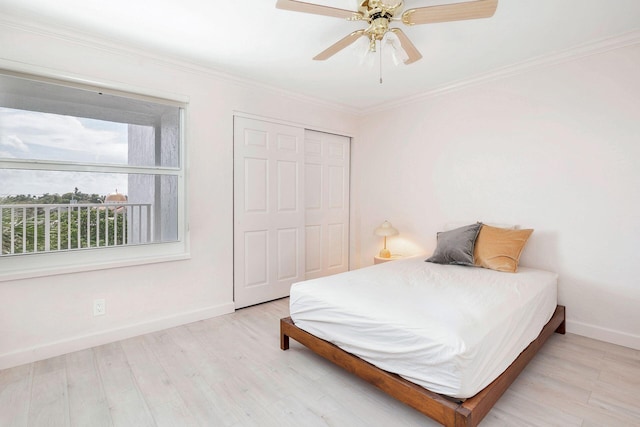 bedroom with light hardwood / wood-style floors, ceiling fan, crown molding, and a closet