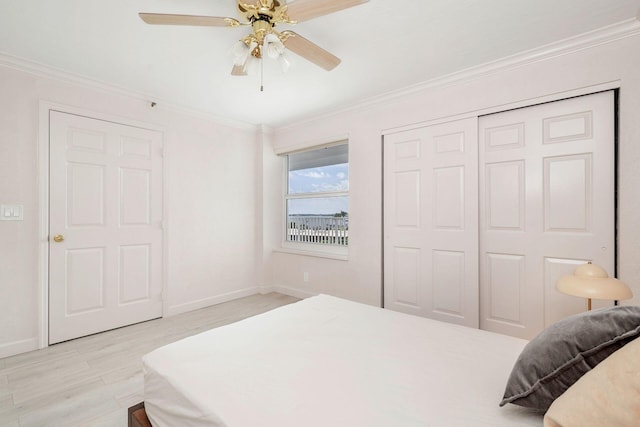 bedroom featuring ornamental molding, a closet, light hardwood / wood-style floors, and ceiling fan