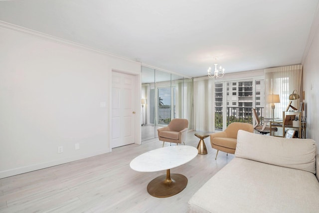 living room with an inviting chandelier, ornamental molding, and light hardwood / wood-style flooring