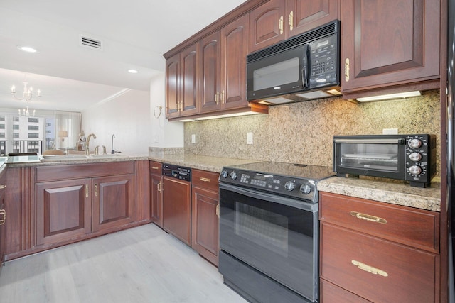 kitchen with sink, black appliances, a chandelier, light hardwood / wood-style flooring, and decorative backsplash