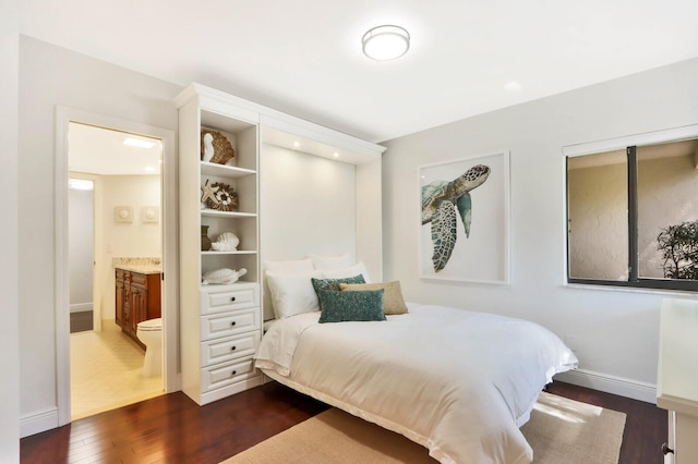 bedroom featuring connected bathroom and dark hardwood / wood-style flooring