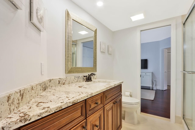 bathroom with vanity, toilet, walk in shower, and wood-type flooring