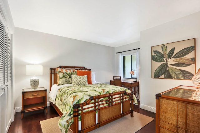 bedroom with dark hardwood / wood-style flooring and a closet