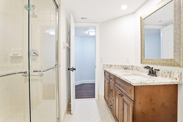 bathroom with tile patterned flooring, vanity, and walk in shower