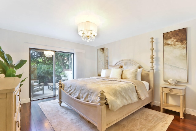 bedroom with dark hardwood / wood-style flooring, access to outside, and a notable chandelier