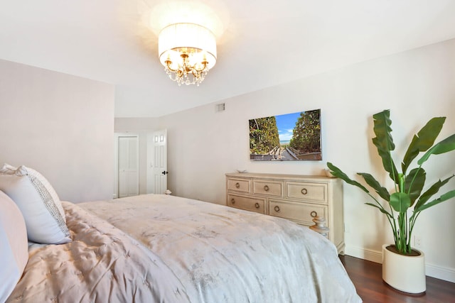 bedroom with a notable chandelier and dark hardwood / wood-style floors