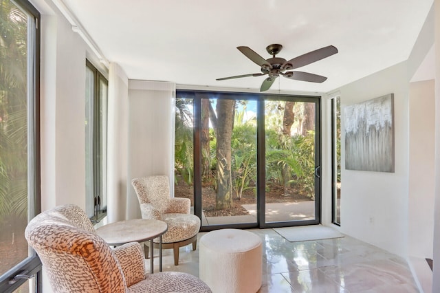 sitting room with a wealth of natural light, ceiling fan, and floor to ceiling windows